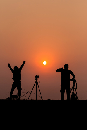Silhouette photographers with sunset backgroundの写真素材