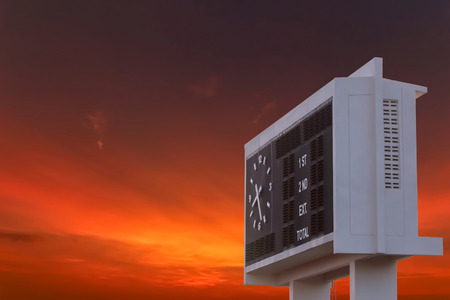 Blank scoreboard at outdoor stadium with sunset sky.の写真素材