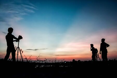 Silhouette photographers with sunset backgroundの写真素材