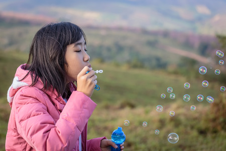 girl blowing bubbles in the mountainsの写真素材