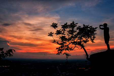 Man stands alone on the peak of mountain, Hiker watching to sunset sky .の写真素材