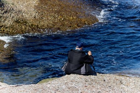 Man by the water getting ready to filmの写真素材