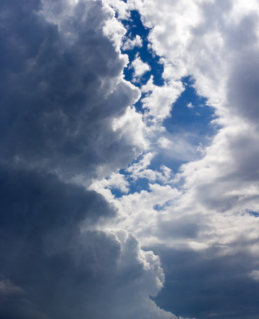 blue sky coming out from behind dark blue stormy cloudsの写真素材