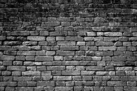 old repaired brick wall as a black-white backgroundの写真素材