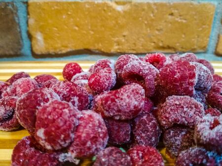 Frozen raspberry. Close up. FFrozen raspberry. Close up. Frozen raspberries on wooden tablesrozen raspberries on wooden tablesの写真素材