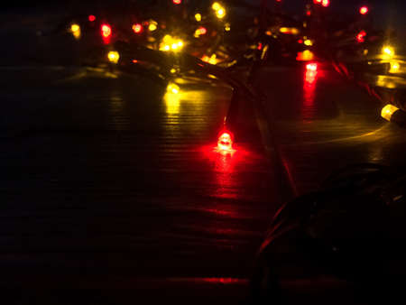 Colored lights Christmas garlands. Christmas background. planked wood with lights and free text space. Glowing Christmas tree garland in the form of a frame on a wooden backgroundの写真素材