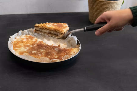 Woman taking piece of apple pies on dark background. Autumn dessert.