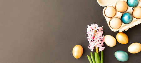 Easter eggs, flowers on dark background. Flat lay, top view, copy space. Easter day.の写真素材