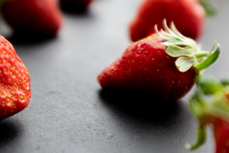 Ripe strawberries on black background, summer berry
