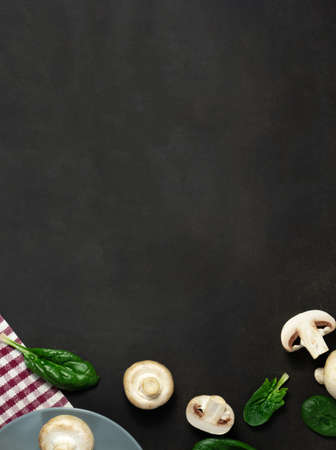 Raw mushrooms champignons on a black background.の写真素材