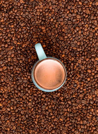Fresh roasted coffee beans background with cup of coffee. Top view.の写真素材