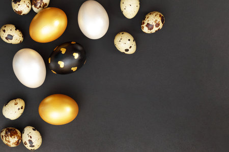 Gold, black and white Easter eggs on a dark gray background.の写真素材