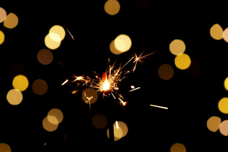 Christmas sparkler Isolated On Black background with Christmas Lights Defocused Bokeh.