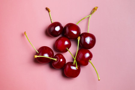 Sweet juicy cherries on a pink background.
