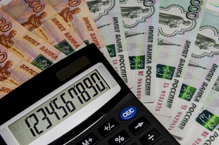 Calculator on background banknote 1000 and 5000 rubles.