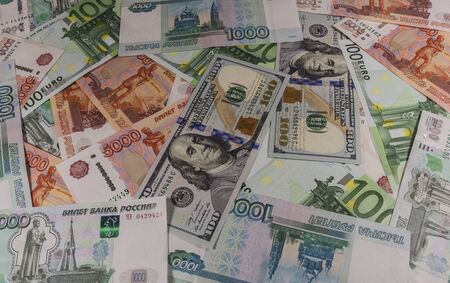 Denominations of 100 rubles 1000 5000 euros and 100 dollars laid out on the table.の写真素材