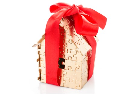 Real estate concept - Hand holding house architectural model with red bow on it, isolatedの写真素材