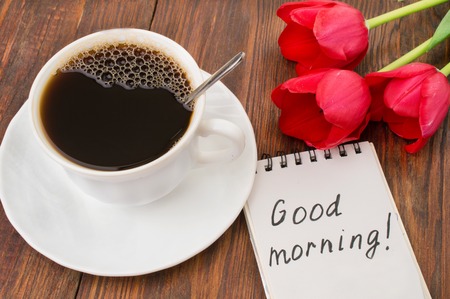 Cup of coffee, tulips and Good morning massage on wooden background