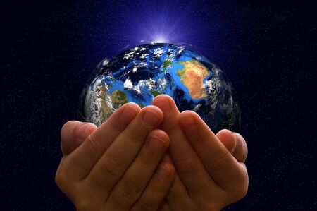 Child holding a glowing earth globe in his hands. Earth image provided by Nasa.