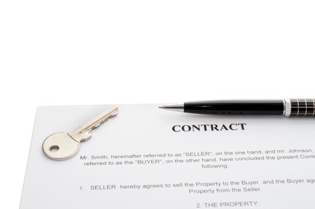 Keys of a new house on a signed contract of house sale with money in background. Concept of closed deal.の写真素材