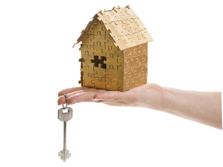 home of gold color puzzles with a keys isolated on white background. Concept: time to buy a houseの写真素材