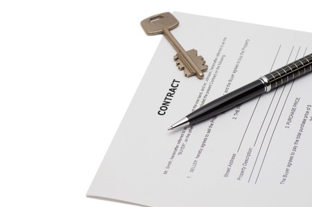 Keys of a new house on a signed contract of house sale with money in background. Concept of closed deal.の写真素材