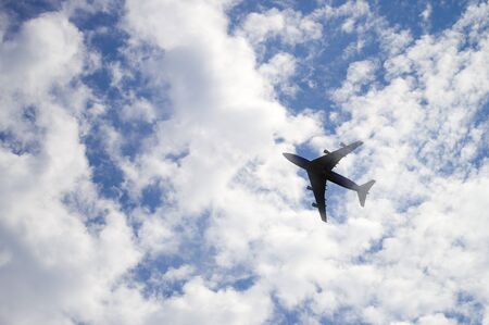 The plane flies in the sky against, the background of cloudsの写真素材