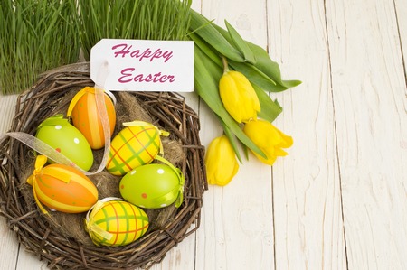 Easter decoration with eggs and tulips on a wooden background.の写真素材