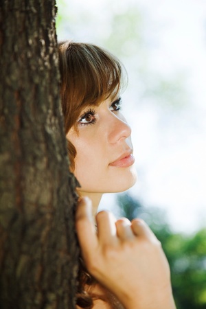 attractive girl leaning against a tree. outdoor shotの写真素材