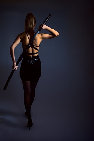portrait of serious girl with katana. studio shotの写真素材