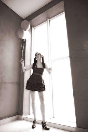 attractive girl with balloons near window. dollの写真素材