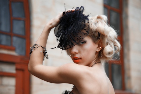 attractive woman in old style black hat. outdoor shot
