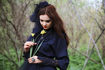 young woman in old style black dress and veilの写真素材