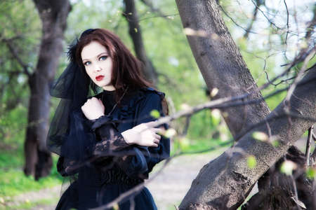 young woman in old style black dress and veilの写真素材