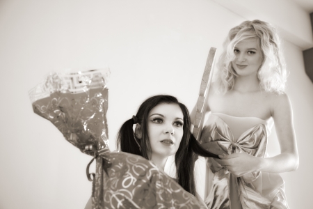 doll combs another doll to get a candyの写真素材