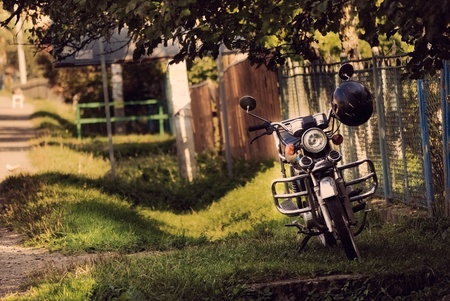 motorbike near fence in villageの写真素材