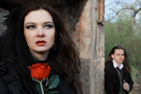 young woman in old style black dress and young manの写真素材