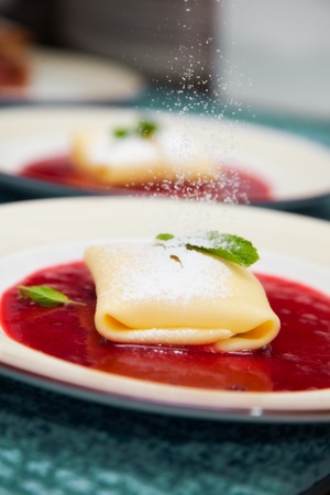 pancake with cherry jam in powdered sugar