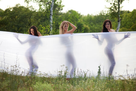 three girls wrapped in white fabric. outdoor shotの写真素材
