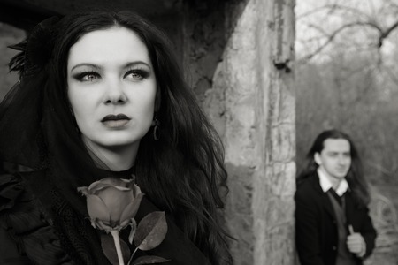 young woman in old style black dress and young man