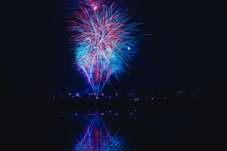 night traditional firework with reflection in waterの写真素材