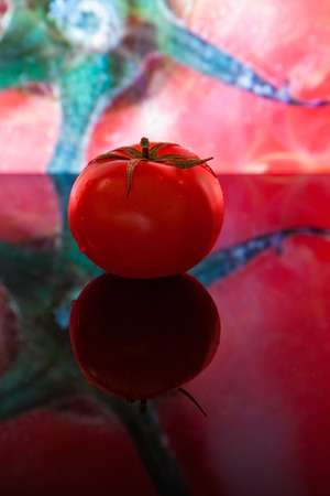 red tomato on the background of own photoの写真素材