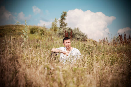 serious guy in a meadowの写真素材