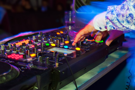 DJ hands on the remote. nightclub