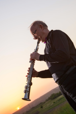 musician, trumpeter playing the instrument at sunsetの写真素材