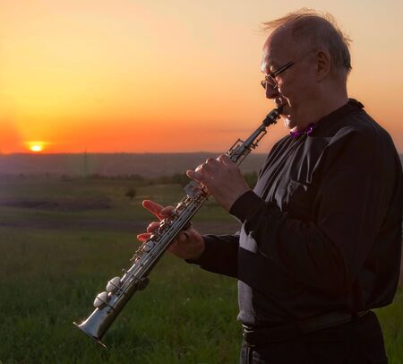 musician, trumpeter playing the instrument at sunsetの写真素材