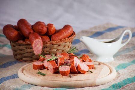 still life sliced sausages on a plate with rosemary, pepper and sauce