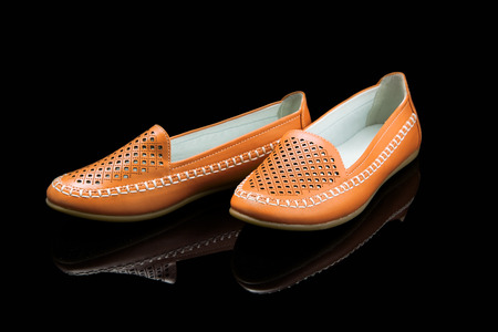 Orange women loafer isolated on black backgroundの写真素材
