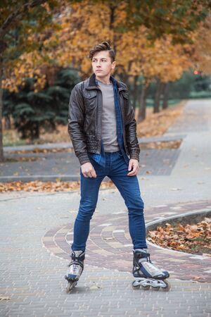 young attractive guy rollerblading in the parkの写真素材