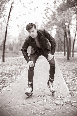 young attractive guy rollerblading in the parkの写真素材